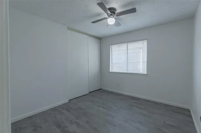 an empty room with a window and a fan