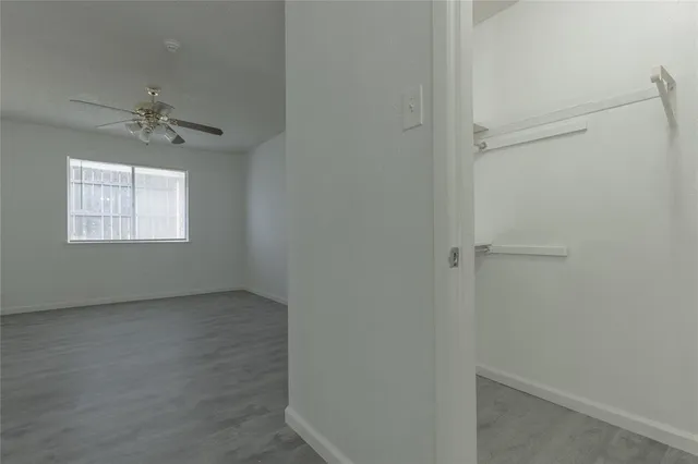 an empty room with windows and fan