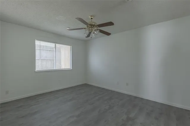 an empty room with a window and a fan