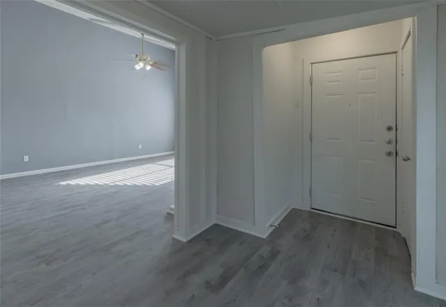 a view of an empty room with wooden floor and closet