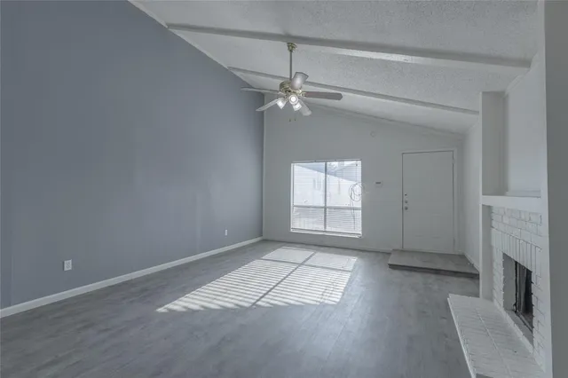 an empty room with fireplace and windows