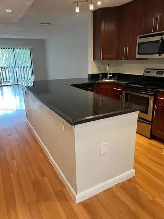 a kitchen with stainless steel appliances granite countertop a sink a stove and a microwave