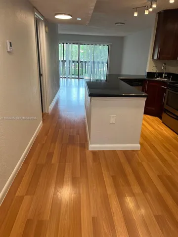 a view of a kitchen with wooden floor and a sink