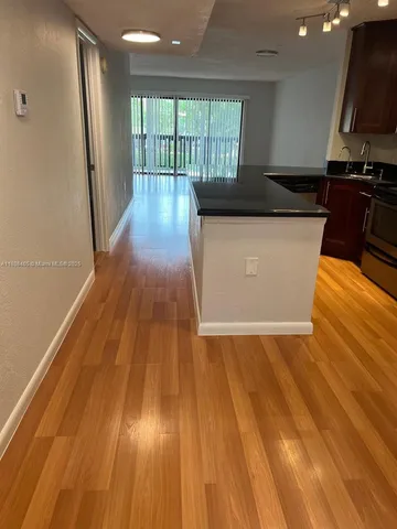 a view of a kitchen with wooden floor and a sink
