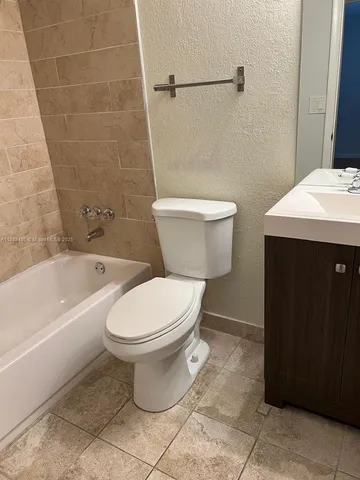 a white toilet sitting next to a bathtub