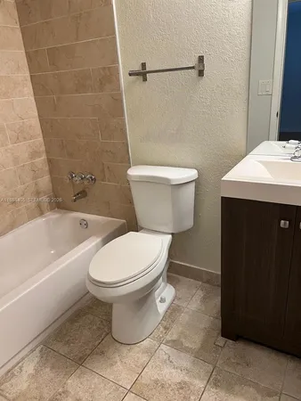 a white toilet sitting next to a bathtub