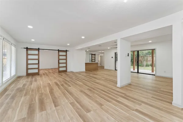 a view of empty room with wooden floor and window