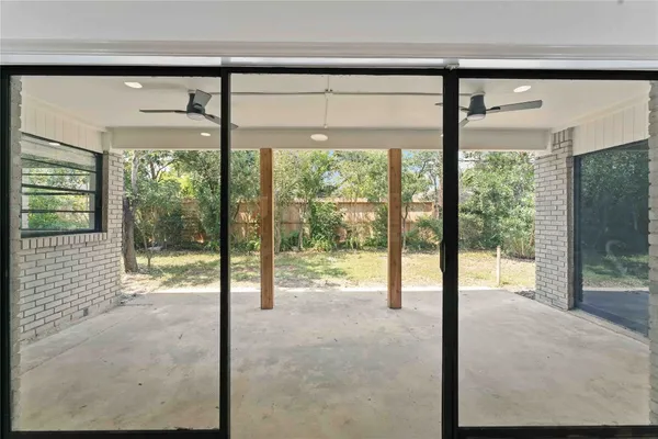 a view of an empty room with wooden floor and a porch