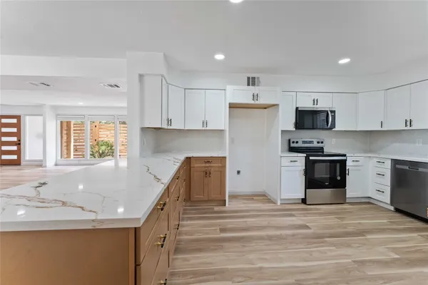 a kitchen with stainless steel appliances granite countertop a sink and a stove top oven