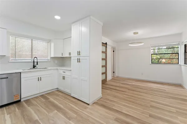 a kitchen with cabinets and wooden floor