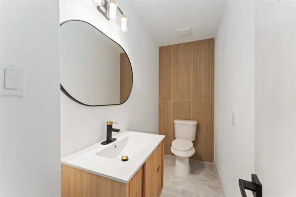 a bathroom with a sink a toilet and a mirror