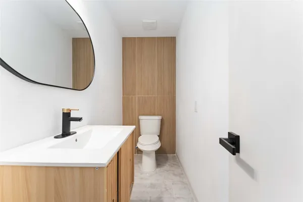 a bathroom with a sink a toilet and a mirror
