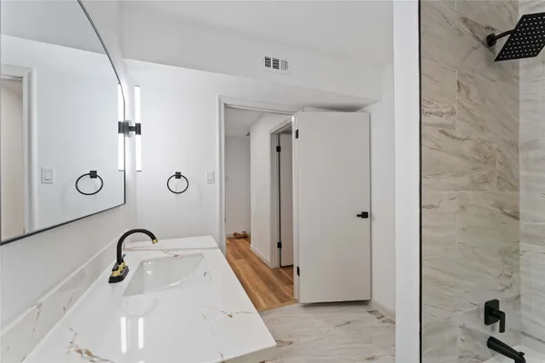 a bathroom with a sink a mirror and a shower