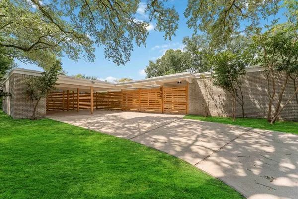 a view of a yard with a house and a large tree