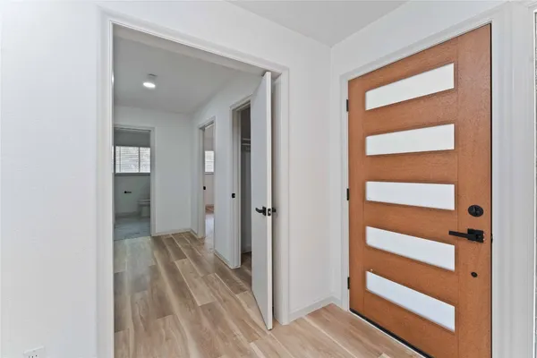 a view of a hallway with wooden floor and closet