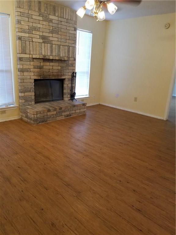 1304 Pitcairn Drive, Unit A Pflugerville, TX 78660 - Photo 3 of 10 an empty room with wooden floor fireplace and chandelier