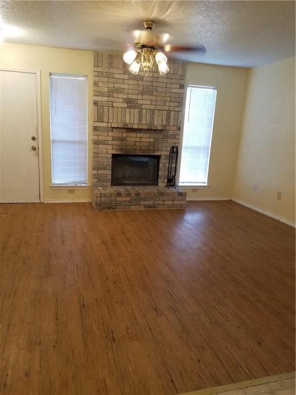 1304 Pitcairn Drive, Unit A Pflugerville, TX 78660 - Photo 4 of 10 a view of a livingroom with a fireplace a chandelier and wooden floor