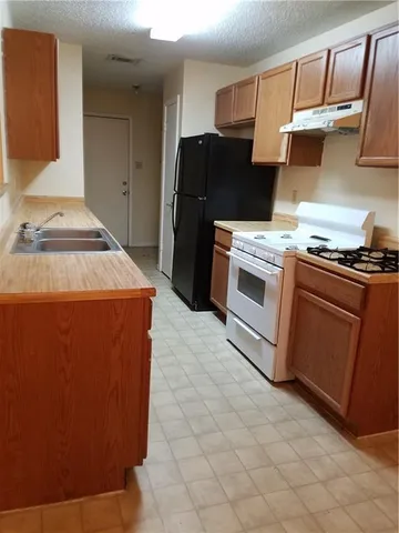a kitchen with a stove top oven and cabinets