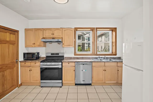 a kitchen with a stove sink and cabinets