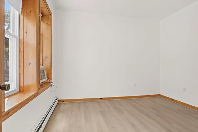 an empty room with wooden floor and a window