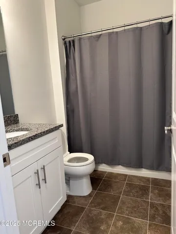 a bathroom with a granite countertop sink toilet and a shower