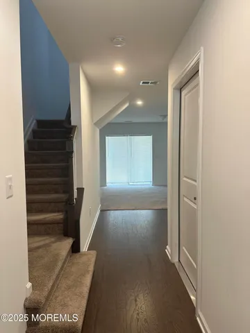 a view of hallway with stairs and wooden floor