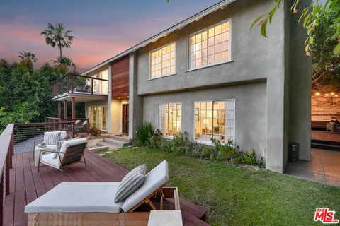 a view of a house with backyard and sitting area