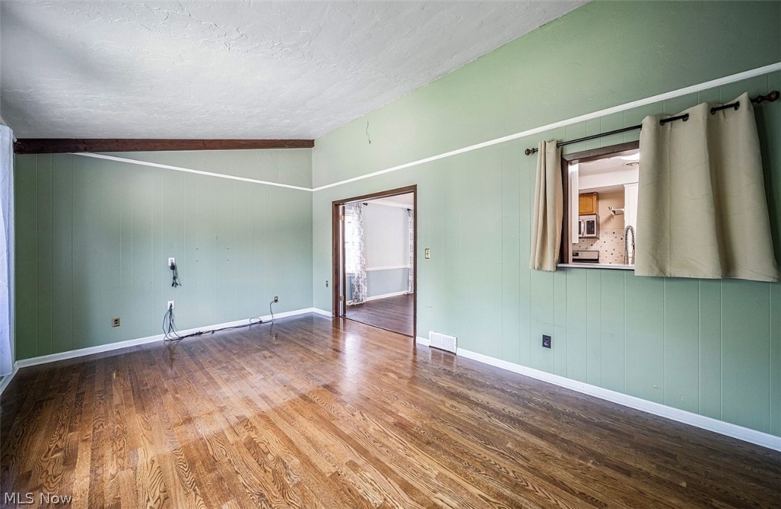 4069 Bushnell Road Cleveland, OH 44121 - Photo 15 of 39 Unfurnished room featuring dark wood-style flooring and wooden walls