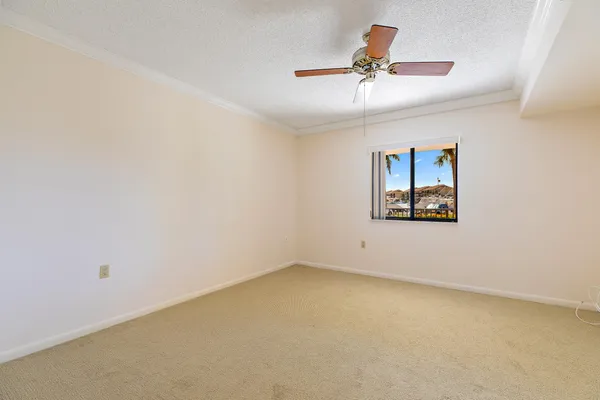 an empty room with a ceiling fan and window