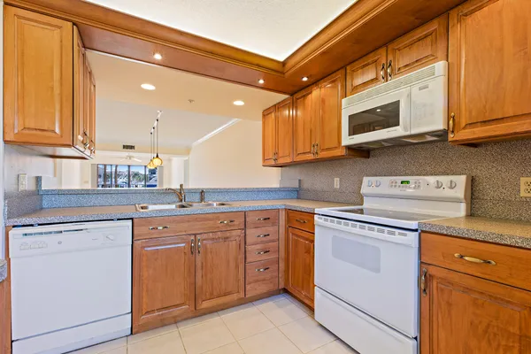 a kitchen with cabinets appliances a sink and a counter top space