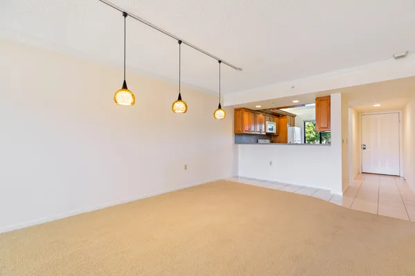 an empty room with a window and chandelier