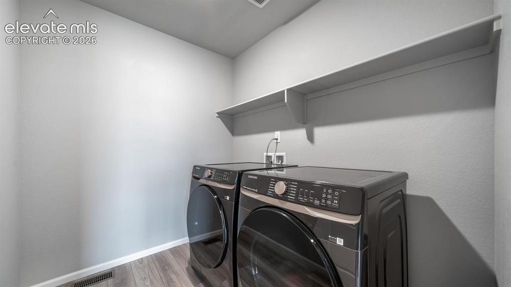 4896 Truscott Road Colorado Springs, CO 80925 - Photo 32 of 34 Dedicated laundry area featuring a built-in wall shelf and wood-finish flooringPhotos of a Model Home