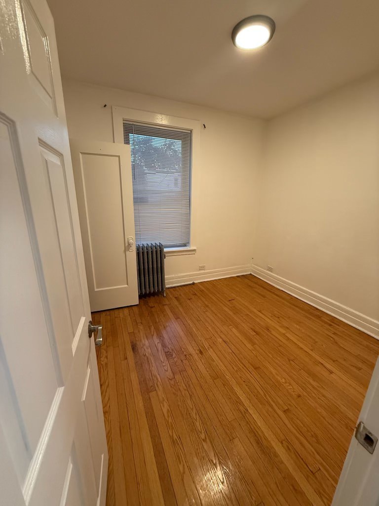 6928 South Green Street, Unit 1S Chicago, IL 60621 - Photo 11 of 12 wooden floor in an empty room