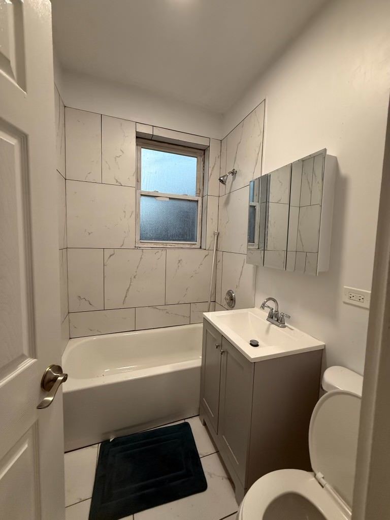 6928 South Green Street, Unit 1S Chicago, IL 60621 - Photo 12 of 12 a bathroom with a sink a toilet and shower