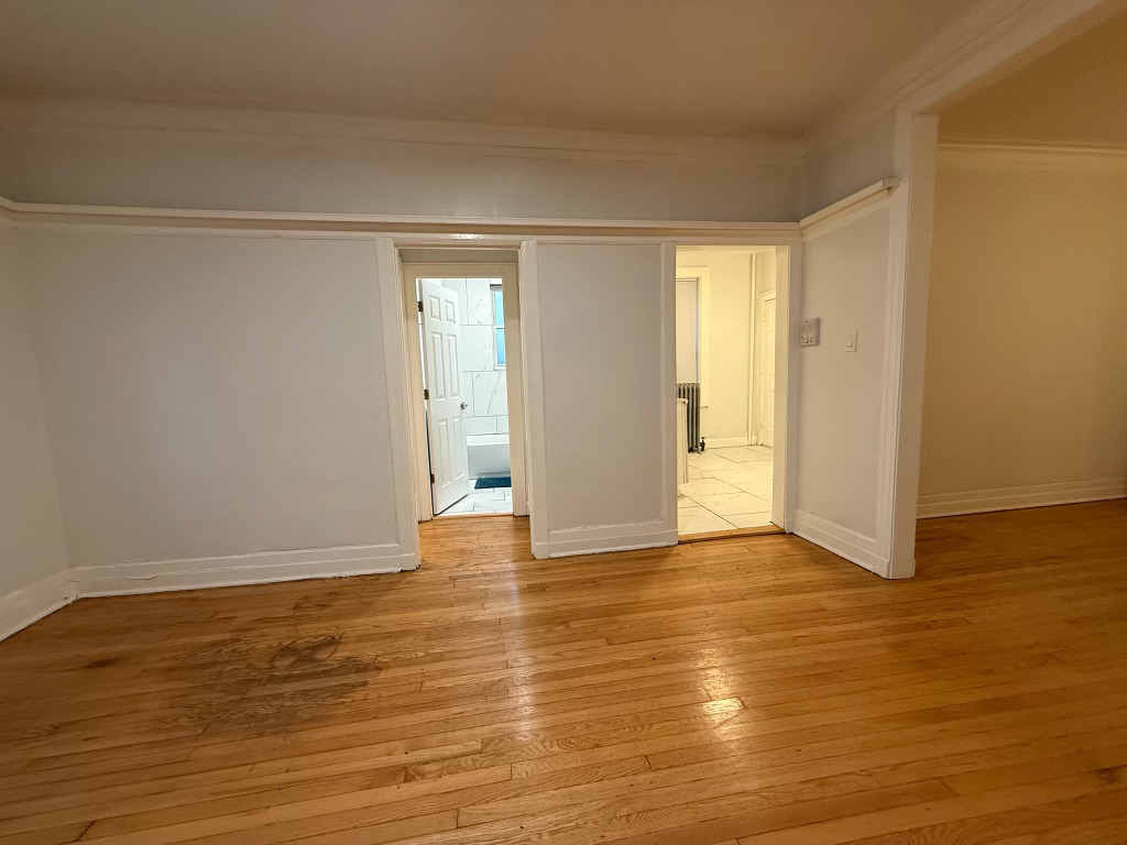 6928 South Green Street, Unit 1S Chicago, IL 60621 - Photo 9 of 12 a view of an empty room with wooden floor and a window