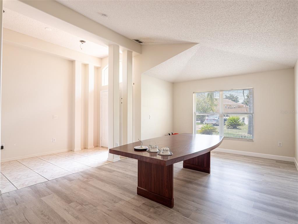 6569 Long Breeze Road Orlando, FL 32810 - Photo 11 of 31 a living room with hard wood floors and a window