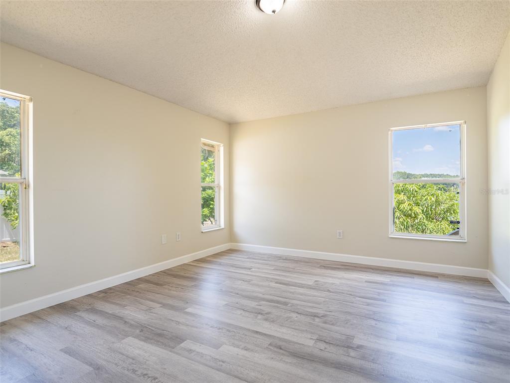 6569 Long Breeze Road Orlando, FL 32810 - Photo 14 of 31 a view of an empty room with wooden floor and a window