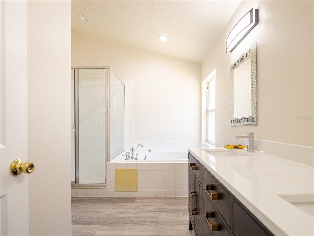 6569 Long Breeze Road Orlando, FL 32810 - Photo 17 of 31 a view of a bathroom with a tub and sink