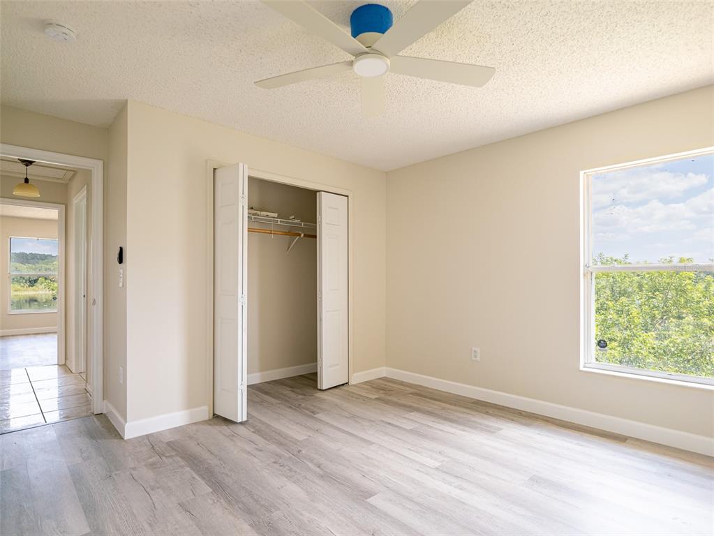 6569 Long Breeze Road Orlando, FL 32810 - Photo 21 of 31 an empty room with wooden floor and windows