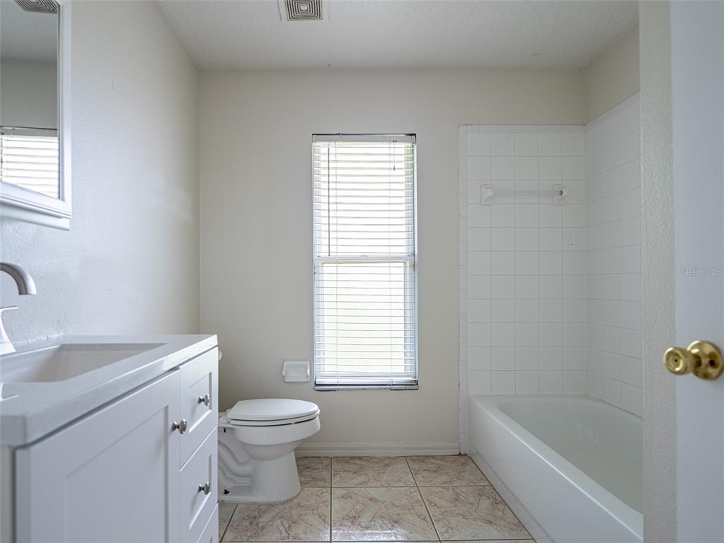 6569 Long Breeze Road Orlando, FL 32810 - Photo 22 of 31 a bathroom with a sink a toilet and a bathtub