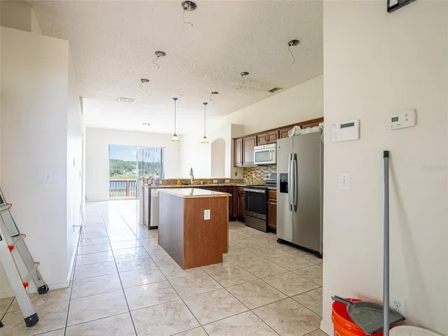 a kitchen with stainless steel appliances granite countertop a refrigerator and a stove