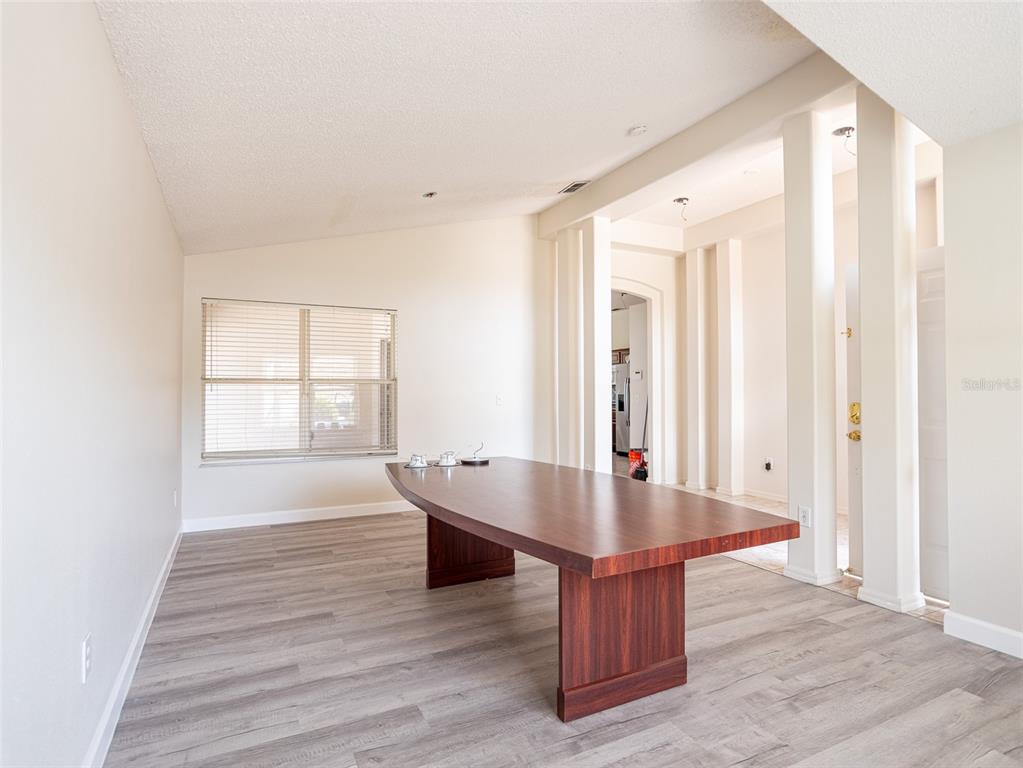 6569 Long Breeze Road Orlando, FL 32810 - Photo 8 of 31 a room with wooden floor and front door