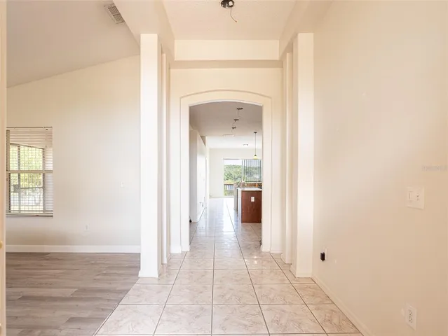 a view of a hallway with wooden floor and a bathroom