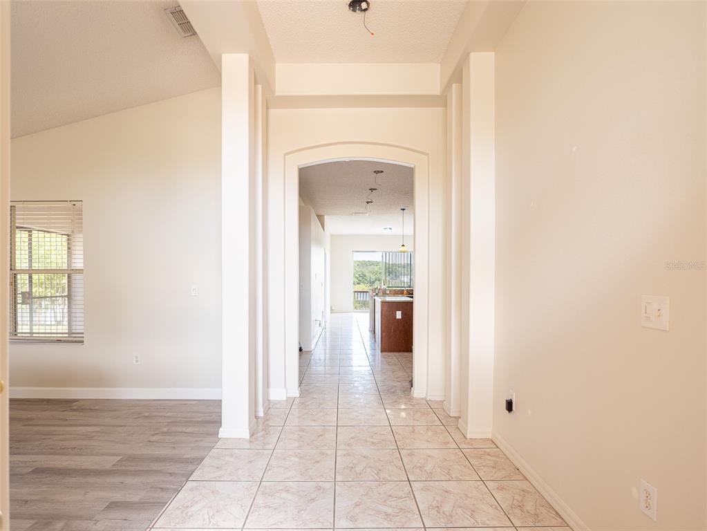 6569 Long Breeze Road Orlando, FL 32810 - Photo 9 of 31 a view of a hallway with wooden floor and a bathroom
