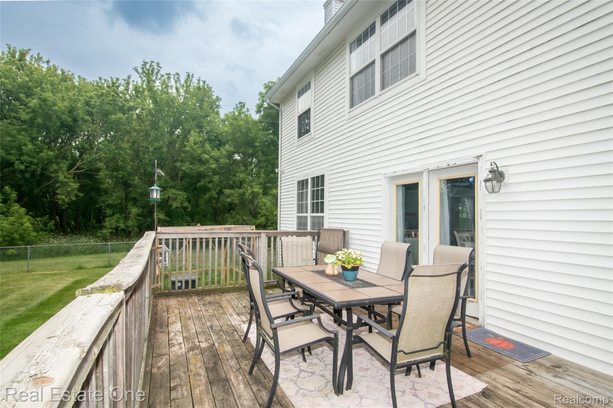 145 Stockbridge Road South Webberville, MI 48892 - Photo 31 of 35 Spacious wooden deck with a surrounding railing and direct access to the interior through a glass-paneled door