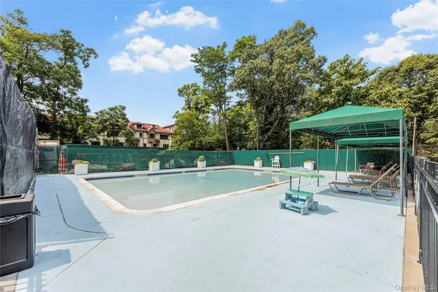 a view of a swimming pool with a yard and outdoor seating