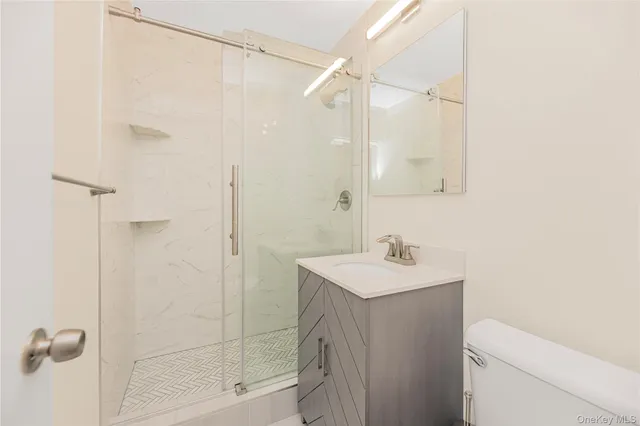 a bathroom with a sink a toilet and shower