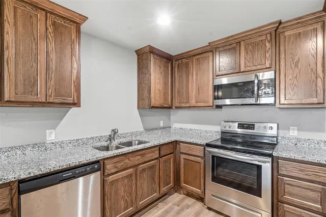 a kitchen with granite countertop a sink and cabinets