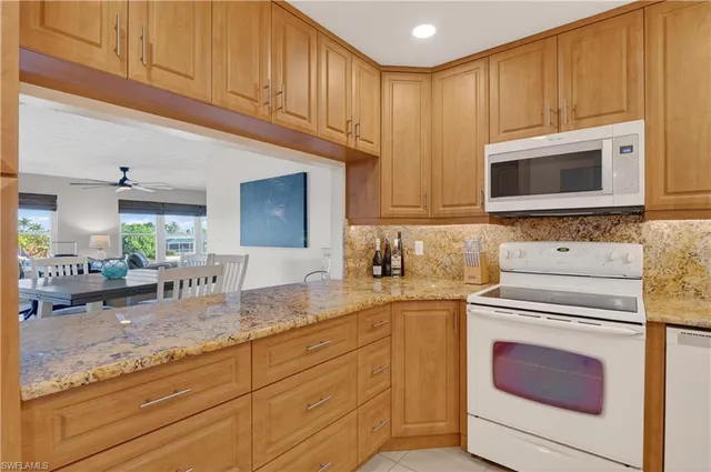 a kitchen with granite countertop cabinets stainless steel appliances and a counter space