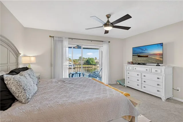 a bedroom with a bed a dresser and a flat screen tv